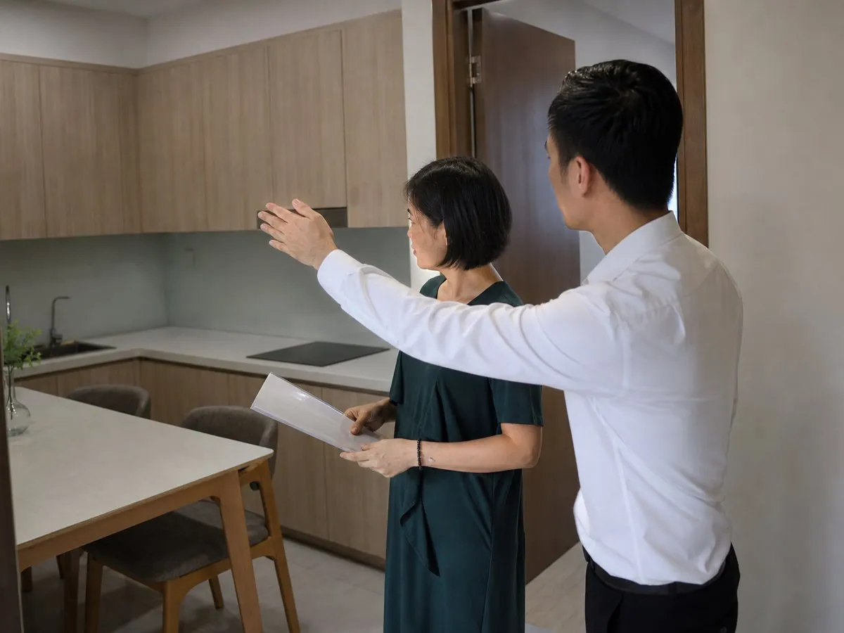 Chủ nhà và chuyên viên tư vấn kiểm tra hiện trạng căn hộ để ước tính giá có thể giao dịch